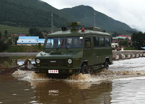 8月10日,在葦沙河鎮(zhèn)的公路上,公安邊防巡邏車涉水巡邏。新華社記者 袁滿 攝