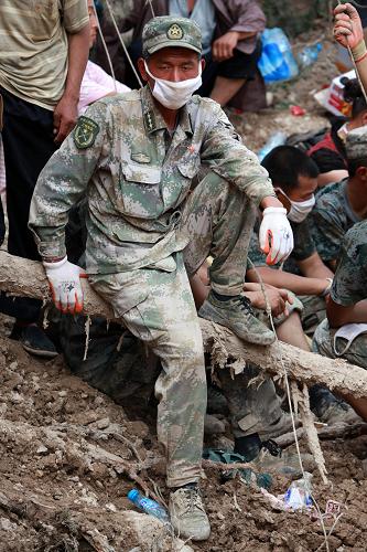 8月10日,蘭州軍區(qū)某部防化團連長彭文惠在救援現(xiàn)場短暫休息。3天來,他和戰(zhàn)士們一起救出8名幸存群眾,挖出24具被埋遺體。新華社記者 李剛 攝