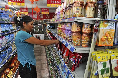 8月13日,一名當(dāng)?shù)鼐用裨谥矍h城的超市里購(gòu)買食品。繼10日舟曲縣城最大的商戶宏源超市開業(yè)后,縣城個(gè)體商戶陸續(xù)恢復(fù)營(yíng)業(yè)。據(jù)了解,舟曲縣城共有700余家個(gè)體工商戶,此次泥石流災(zāi)害使其中的400多家不同程度受損。新華社發(fā)