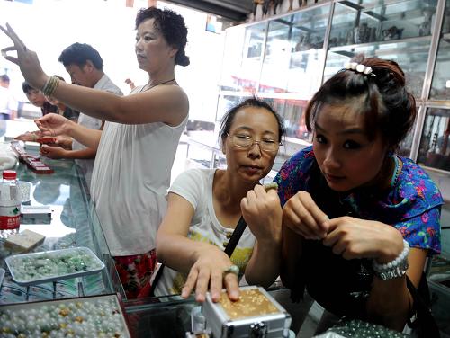 8月13日,在憑祥市浦寨邊貿(mào)區(qū),幾名客商在集體采購(gòu)緬甸翡翠。新華社記者 張愛(ài)林 攝