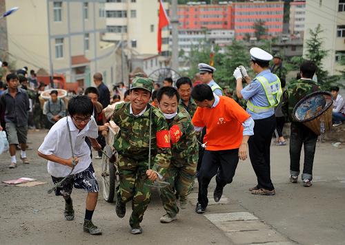 8月14日,志愿者在舟曲縣三中受災(zāi)群眾安置點(diǎn)搬運(yùn)磚塊。新華社記者 王鵬 攝