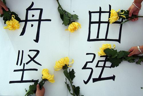 8月14日,山東郯城縣新愛嬰幼兒園的孩子們?yōu)橹矍鲭y同胞獻(xiàn)上黃菊,寄托哀思。新華社發(fā)(張春雷 攝)