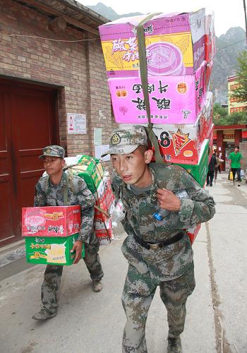 8月14日,戰(zhàn)士李旭(前)和戰(zhàn)友一起為受災群眾徒步背送食品。新華社記者 李剛 攝