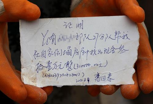 8月8日,蘭州軍區(qū)某部防化團排長劉啟安帶領9名戰(zhàn)士從廢墟中挖出30多萬元現(xiàn)金。在當?shù)嘏沙鏊膸椭拢俦鴤儗⒕蘅钊鐢?shù)交還物主惠回春,并謝絕了他的報酬。這是物主寫給救援部隊的證明(8月14日攝)。新華社記者 李剛 攝
