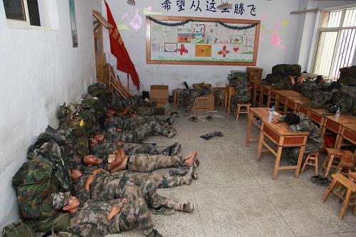 8月14日,為了減輕災區(qū)群眾負擔,救援官兵躺在水泥地上睡覺。新華社記者 李剛 攝