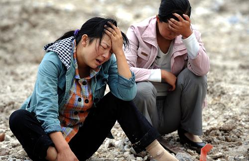 8月14日,兩位遇難者家屬在泥石流現(xiàn)場(chǎng)緬懷遇難的親人。新華社記者陶明攝