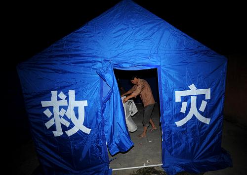 8月18日晚,云南怒江州貢山普拉底鄉(xiāng)一名受災(zāi)群眾在剛搭好的簡(jiǎn)易帳篷內(nèi)整理被褥。新華社記者 藺以光 攝