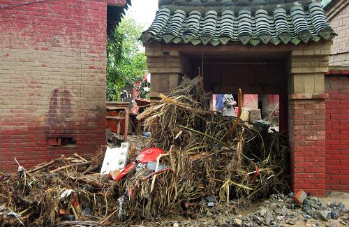 山洪過后,成縣黃渚鎮(zhèn)王莊一戶人家的大門被樹木殘枝堵塞(8月20日攝)。新華社記者 吳明軒 攝