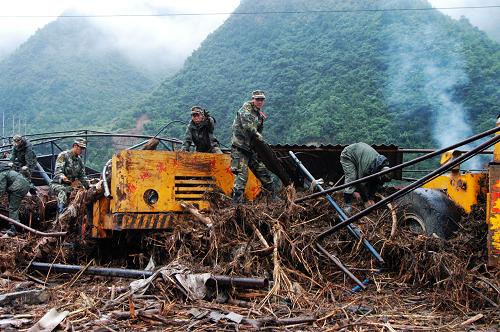 武警隴南森林支隊(duì)官兵正在清理被洪水淤積物淹沒的工程車(8月20日攝)。新華社記者 吳明軒 攝