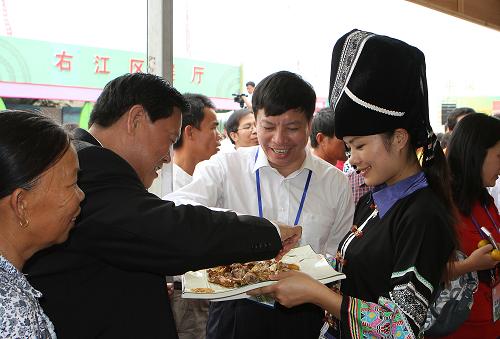 10月25日,在中國(guó)—東盟現(xiàn)代農(nóng)業(yè)展示交易會(huì)上,客商在品嘗壯家特色美食。新華社發(fā)(馬震宇 攝)