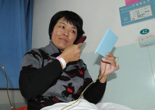 12月27日,尚小芳坐在病床上梳理頭發(fā),為出院做準(zhǔn)備。新華社記者 王艷明 攝