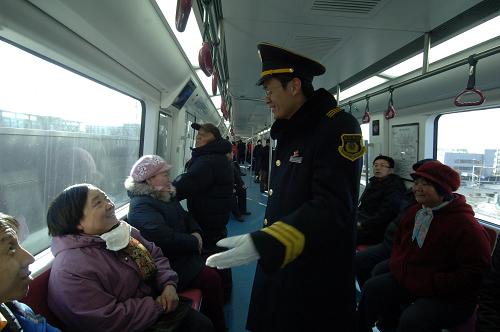 12月30日,北京地鐵工作人員在亦莊線(xiàn)首班車(chē)上向乘客介紹情況。新華社記者 趙琬微 攝