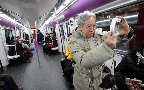 12月30日,搭乘新開通的北京地鐵十五號線的乘客在列車上拍照。新華社記者李文攝