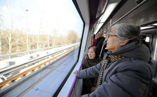 12月30日,搭乘新開通的北京地鐵十五號線的乘客在欣賞窗外風(fēng)景。新華社記者 李文 攝