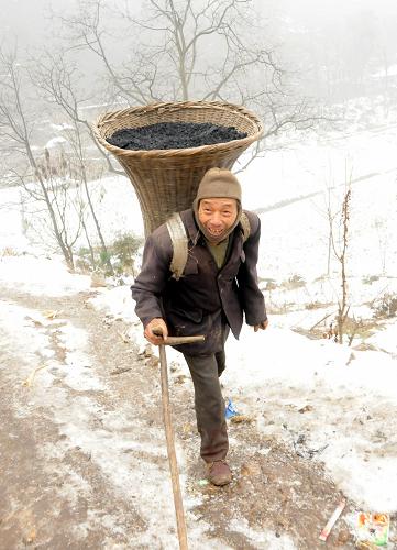 1月29日,威寧縣金鐘鎮(zhèn)大營村一位村民將分配到的燃煤背回家。新華社記者 李勁峰 攝