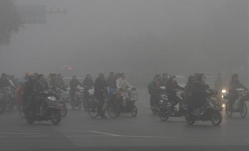 2月22日晨,揚(yáng)州市民在大霧中騎車(chē)出行。新華社發(fā)(莊文斌 攝)