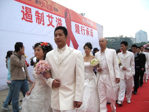 12月1日,新人們步入世界艾滋病日宣傳活動(dòng)現(xiàn)場(chǎng)。 當(dāng)日是世界艾滋病日,廣西南寧市19對(duì)新人在民族廣場(chǎng)舉行集體婚禮,支持預(yù)防艾滋病公益宣傳活動(dòng)。