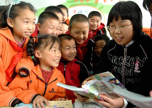 3月10日,沈陽市農(nóng)民工子女就學指定學校砂山街第四小學二年二班的老師宋鈴(右)在給同學們講故事。