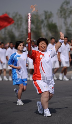6月25日,“全國優(yōu)秀母親”---火炬手楊春霞在進行傳遞。新華社記者 燕雁 攝