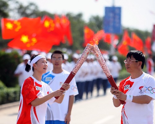 6月25日,火炬手趙效清(右)與火炬手鄭曉雪在進行傳遞。當日,北京奧運會圣火在山西平遙傳遞。 新華社記者邢廣利攝