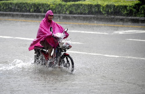 6月25日,一位市民在深圳積水嚴(yán)重的路面上騎車。當(dāng)日清晨,2008年第6號(hào)強(qiáng)熱帶風(fēng)暴“風(fēng)神”減弱為熱帶風(fēng)暴,并于5時(shí)30分在深圳葵涌沿海地區(qū)登陸,登陸時(shí)中心附近最大風(fēng)力9級(jí)。深圳氣象局在全市陸地及海區(qū)發(fā)布臺(tái)風(fēng)黃色預(yù)警信號(hào),全市中小學(xué)停課。 新華社記者 劉大偉 攝