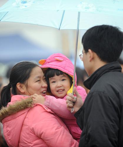 1月20日,重慶汽車站露天候車點,一家三口正在小雨中等待回家的客車。1月19日,重慶市公路安全發(fā)送旅客達到117.54萬人次。春運以來,重慶公路共安排各類旅客班車18萬多班次,安全運送旅客超過千萬人次,與2008年同期相比上升9.07%。新華社記者 周衡義攝