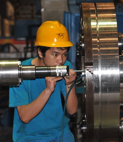 4月17日,東方汽輪機廠的一名工人在60萬千瓦汽輪機高壓轉子旁工作。新華社記者 何俊昌 攝