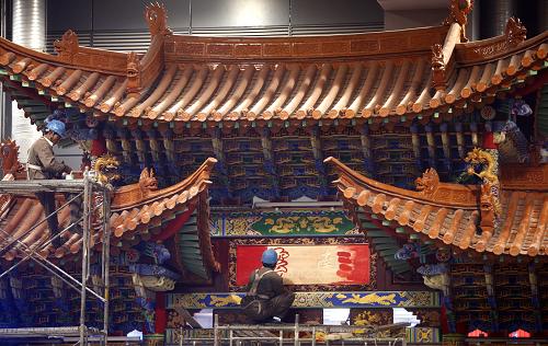 3月29日,工人們正在給云南館的門樓上色。 當(dāng)日,距離上海世博會(huì)開幕還有33天,位于中國(guó)館腳下的31個(gè)省區(qū)市館的布展工作已進(jìn)入沖刺階段,不少展館雛形初現(xiàn),展現(xiàn)了濃郁的民族風(fēng)情和獨(dú)特的地域文化。 新華社記者 裴鑫 攝