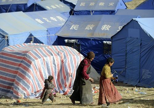 4月26日,在玉樹縣結(jié)古鎮(zhèn)扎西大同村,藏族群眾走過防震帳篷。 當(dāng)日,青海省副省長張光榮在國務(wù)院新聞辦舉行的新聞發(fā)布會上介紹,截至4月25日17時,地震災(zāi)區(qū)已經(jīng)發(fā)放帳篷59093頂,棉被207959套,棉衣117027件,食品及飲用水1670噸,火爐子13000個,燃煤1520噸,基本保證群眾有飯吃、有干凈水喝、有帳篷住。下一步將堅持一手抓有序救災(zāi)、一手抓災(zāi)后重建,把妥善安置受災(zāi)群眾生活、全面恢復(fù)正常秩序和災(zāi)后重建放在更加突出的位置。 新華社記者 郭磊 攝