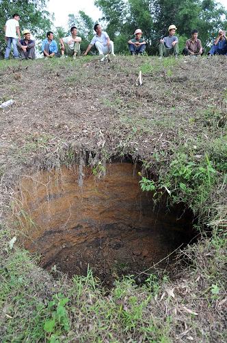 6月8日,在廣西來賓市興賓區(qū)良江鎮(zhèn)凌口水庫,人們?cè)诖髩纬霈F(xiàn)大坑的上方待命。 當(dāng)日,廣西來賓市興賓區(qū)良江鎮(zhèn)凌口水庫大壩出現(xiàn)塌陷,當(dāng)?shù)卣谵D(zhuǎn)移下游群眾。 據(jù)介紹,興賓區(qū)良江鎮(zhèn)凌口水庫庫容58萬立方米,設(shè)計(jì)庫容62萬立方米。大壩出現(xiàn)一個(gè)直徑2米、深1米的大坑,3個(gè)漏水點(diǎn)。漏水流量0.1立方米/秒,危及下游3個(gè)村莊2500多群眾的安全。 新華社記者 周華 攝