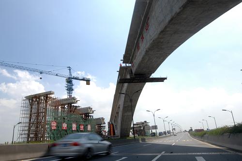 8月7日,車輛從經(jīng)過轉(zhuǎn)體后順利實(shí)現(xiàn)合龍的滬杭高鐵大橋下駛過。 當(dāng)日,滬杭鐵路客運(yùn)專線(滬杭高鐵)杭州段跨石大路橋轉(zhuǎn)體橋順利實(shí)現(xiàn)轉(zhuǎn)體合龍,標(biāo)志著滬杭鐵路客運(yùn)專線工程取得決定性的勝利。 滬杭鐵路客運(yùn)專線跨石大路轉(zhuǎn)體橋主跨160米,單個轉(zhuǎn)體橋梁重量達(dá)1.68萬噸。滬杭客專轉(zhuǎn)體拱橋建設(shè)應(yīng)用了5項(xiàng)中國自主創(chuàng)新技術(shù),克服了精度高、技術(shù)新,地質(zhì)復(fù)雜等難題,實(shí)現(xiàn)了我國乃至世界高速鐵路施工技術(shù)的突破。 新華社記者 黃宗治 攝