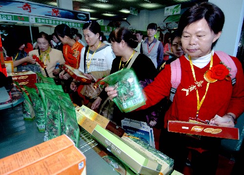 11月17日,來自臺灣的客商陳女士(右一)在首屆海峽兩岸茶業(yè)博覽會上選購大陸茶業(yè)制品。新華社記者 張國俊 攝