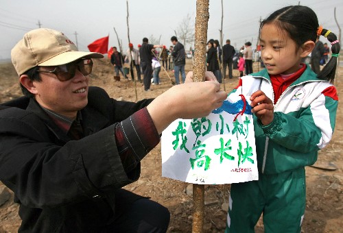 3月16日,一對父女志愿者將心愿牌系在樹上。當(dāng)日,山西省運城市開展以“盡公民義務(wù),為奧運添綠”為主題的全民公益植樹活動,800多名志愿者在運(城)解(州)旅游線解州段的防風(fēng)林帶種下600多棵樹苗。 新華社發(fā)(薛俊 攝)