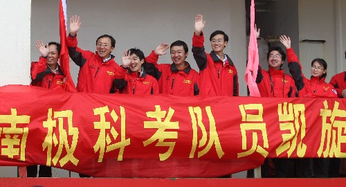 4月15日,科考隊員在即將靠岸的“雪龍”號上向歡迎的人群揮手致意。 新華社記者 裴鑫 攝