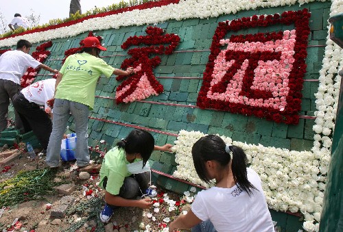 6月2日,志愿者在綿竹市體育中心受災(zāi)群眾集中安置點擺放鮮花。 近日,一場以“綠絲帶 鮮花 精神家園”為主題的活動在地震災(zāi)區(qū)四川綿竹進行。由貴州志愿者提供的200萬朵鮮花被布置在漢旺鎮(zhèn)鐘樓、綿竹體育中心受災(zāi)群眾安置點等地方,為災(zāi)區(qū)群眾送上祝福,鼓舞士氣。 新華社發(fā)(戚振林 攝)