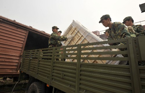 6月9日,解放軍戰(zhàn)士在濟(jì)南火車貨運(yùn)站裝載援川物資。 新華社記者 朱崢 攝
