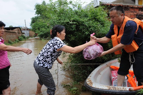 6月13日,救援人員將食品送到永??h永福鎮(zhèn)樟峽村受困群眾手中。 新華社記者 陳瑞華 攝