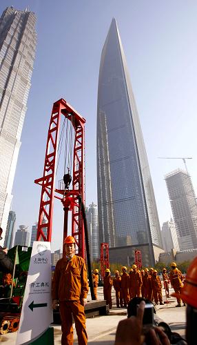 11月29日,一位工人在開工儀式上拍照留念。當日,設計總高度達632米的上海中心大廈正式開工,它將超過492米的上海環(huán)球金融中心,是目前國內(nèi)規(guī)劃中的第一高樓。“上海中心”總投入將達148億元,預計將在2014年竣工交付使用。新華社記者 凡軍攝