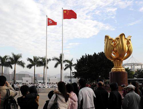 1月1日,市民和游客在觀看升旗。當日,香港金紫荊廣場舉行元旦升旗儀式,鮮艷的五星紅旗在香港特別行政區(qū)區(qū)旗的伴隨下冉冉升起,大批市民和游客前來觀看。新華社記者 黃本強 攝
