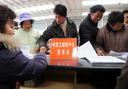 1月16日,一些農(nóng)民工在維權(quán)宣傳點(diǎn)前領(lǐng)取宣傳資料。新華社記者 藺以光 攝
