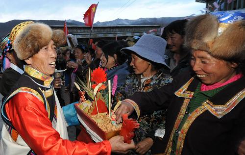 3月23日,西藏山南地區(qū)結(jié)巴鄉(xiāng)結(jié)巴村農(nóng)民互敬象征五谷豐登的“切瑪”,喜迎農(nóng)奴解放日。新華社記者 格桑達(dá)瓦 攝