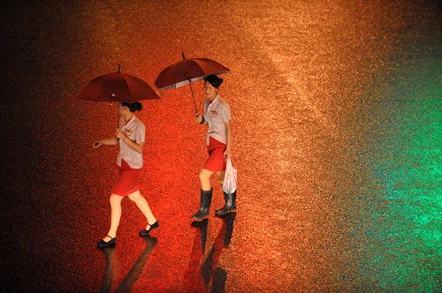 6月26日深夜,兩位市民打著雨傘走在霓虹燈和路燈照射下的深圳街頭。新華社記者 陳曄華攝