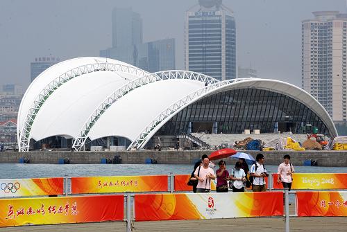 6月29日,游客在青島奧帆中心內(nèi)游覽,背景為正在建設(shè)中的海上劇場。目前,在青島奧帆中心丈量碼頭上新建的海上劇場基本完工。海上劇場將把水幕、噴泉、激光等高科技元素融入其中,將室內(nèi)演出與室外實(shí)景相結(jié)合,預(yù)計(jì)于8月正式亮相并舉行首場演出,屆時(shí)觀眾可以在岸邊欣賞大型全海景實(shí)景演出。新華社記者 李紫恒 攝