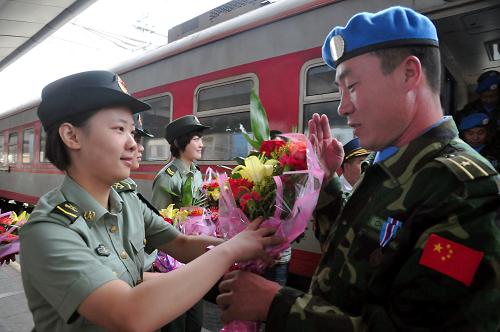 8月20日,一名女戰(zhàn)士向凱旋的維和官兵獻(xiàn)花。新華社發(fā)(范德銀 攝)