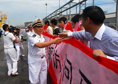 12月6日,在馬來(lái)西亞雪蘭莪州巴生港,中國(guó)海軍“徐州”號(hào)導(dǎo)彈護(hù)衛(wèi)艦上的指揮官與歡迎群眾握手。新華社記者 熊平攝