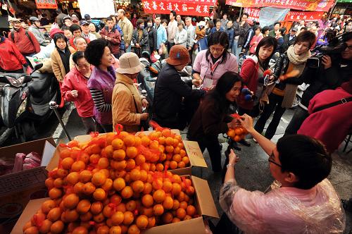 2月7日,在臺(tái)北市濱江商圈年貨大街,人們排隊(duì)購(gòu)買特價(jià)蔬果。新華社發(fā)(吳景騰 攝)