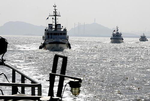 3月11日,海事巡邏艇和漁政、公安執(zhí)法船進(jìn)行海上編隊(duì)巡邏。當(dāng)日,上海海事局洋山海事處聯(lián)合漁政以及海事公安等部門,對(duì)上海洋山深水港海域礙航漁網(wǎng)漁具進(jìn)行了專項(xiàng)清理整治。眼下正值一年一度的鰻魚捕撈時(shí)節(jié),不少漁民在本就緊張的洋山海域航道上違法設(shè)置礙航捕撈網(wǎng)具,對(duì)來自世界各國運(yùn)輸世博會(huì)參展物資的大型進(jìn)港集裝箱船舶造成極大的安全隱患,整治活動(dòng)旨在全力確保2010年上海世博會(huì)通航水域的安全暢通。新華社記者 陳飛攝
