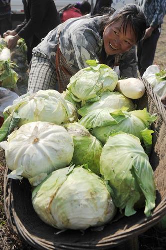 3月12日,貴州水城縣陡菁苗族彝族鄉(xiāng)冷壩村村民在領(lǐng)取政府發(fā)放的救災(zāi)蔬菜。新華社記者 歐東衢 攝