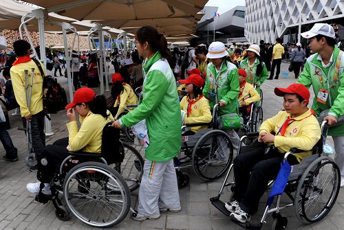 5月8日,在四川省都江堰市友愛小學(xué)就讀的學(xué)生在志愿者幫助下參觀上海世博園。新華社記者 李紫恒攝