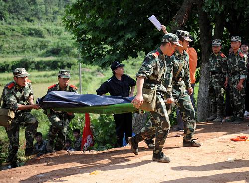 5月23日,武警官兵抬上最后一具被清理出的遇難者遺體。新華社記者 周科 攝